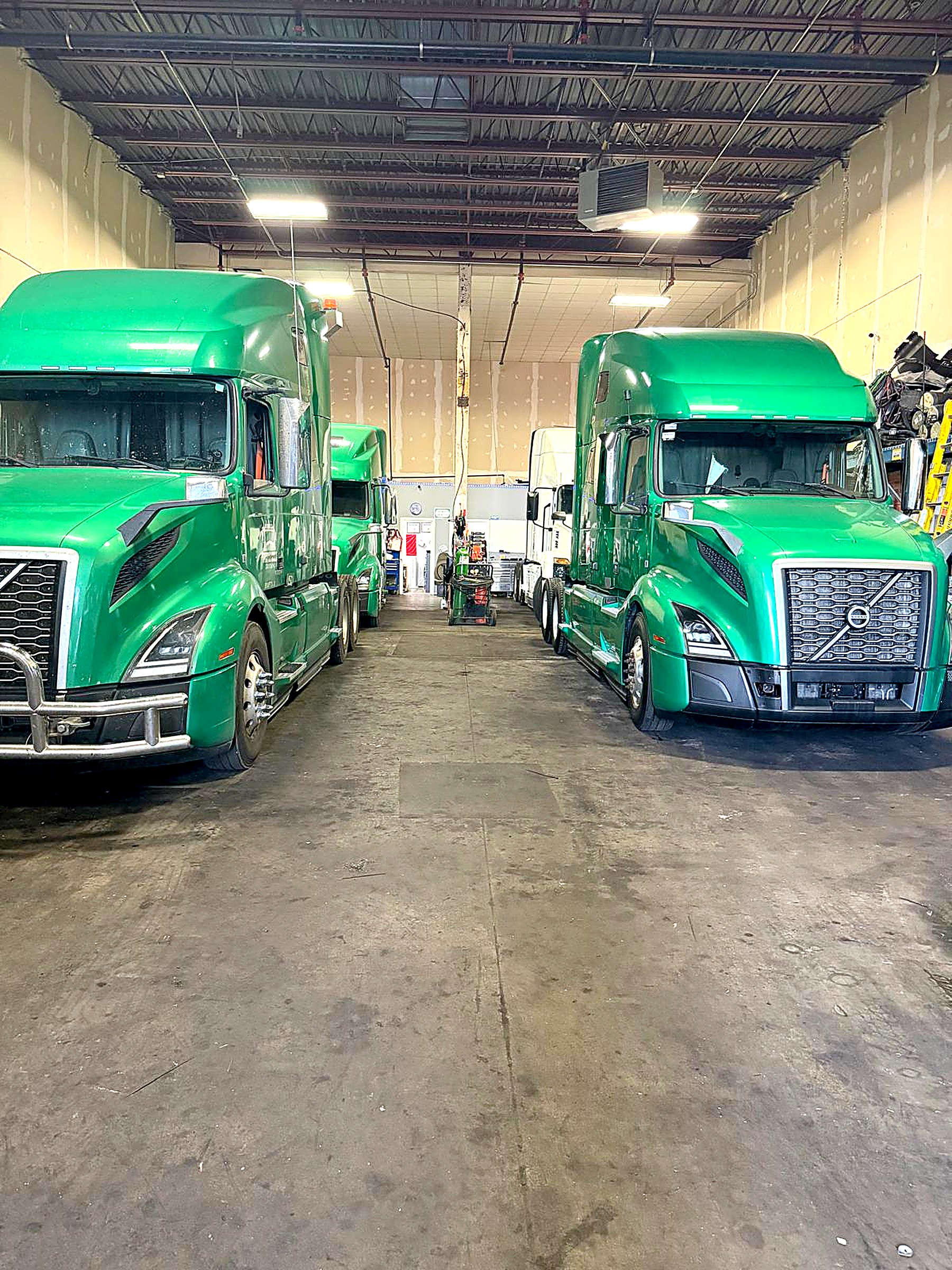 Green Volvo semi-trucks in the repair shop